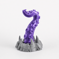 Purple tentacle headphone stand holding black gaming headset on desk setup