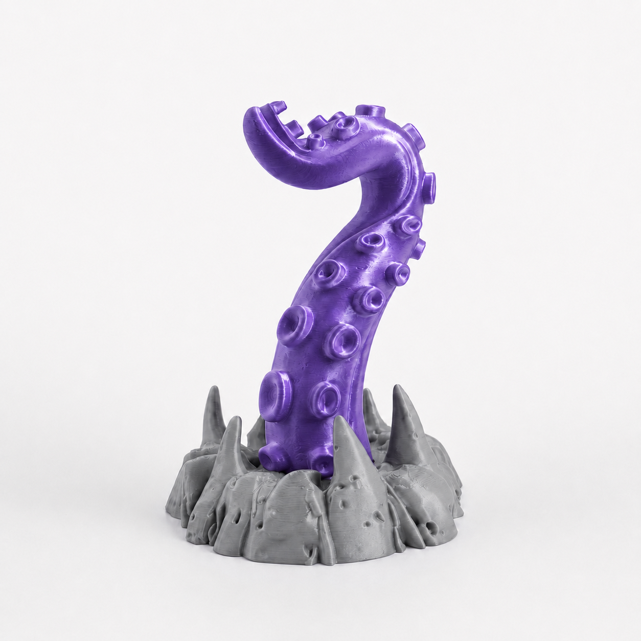 Purple tentacle headphone stand holding black gaming headset on desk setup