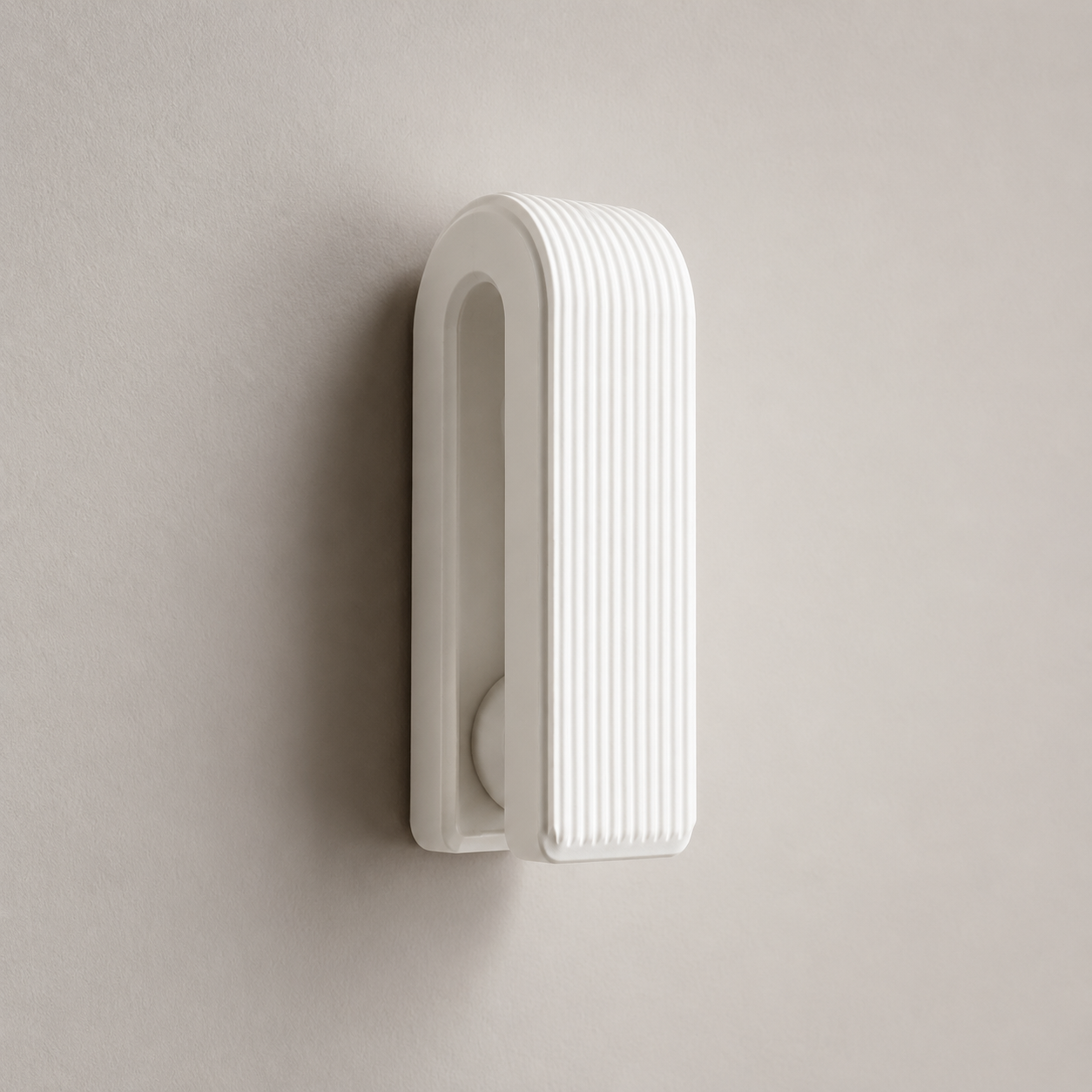 Brown ribbed gravity towel hook holding gray towel in bathroom